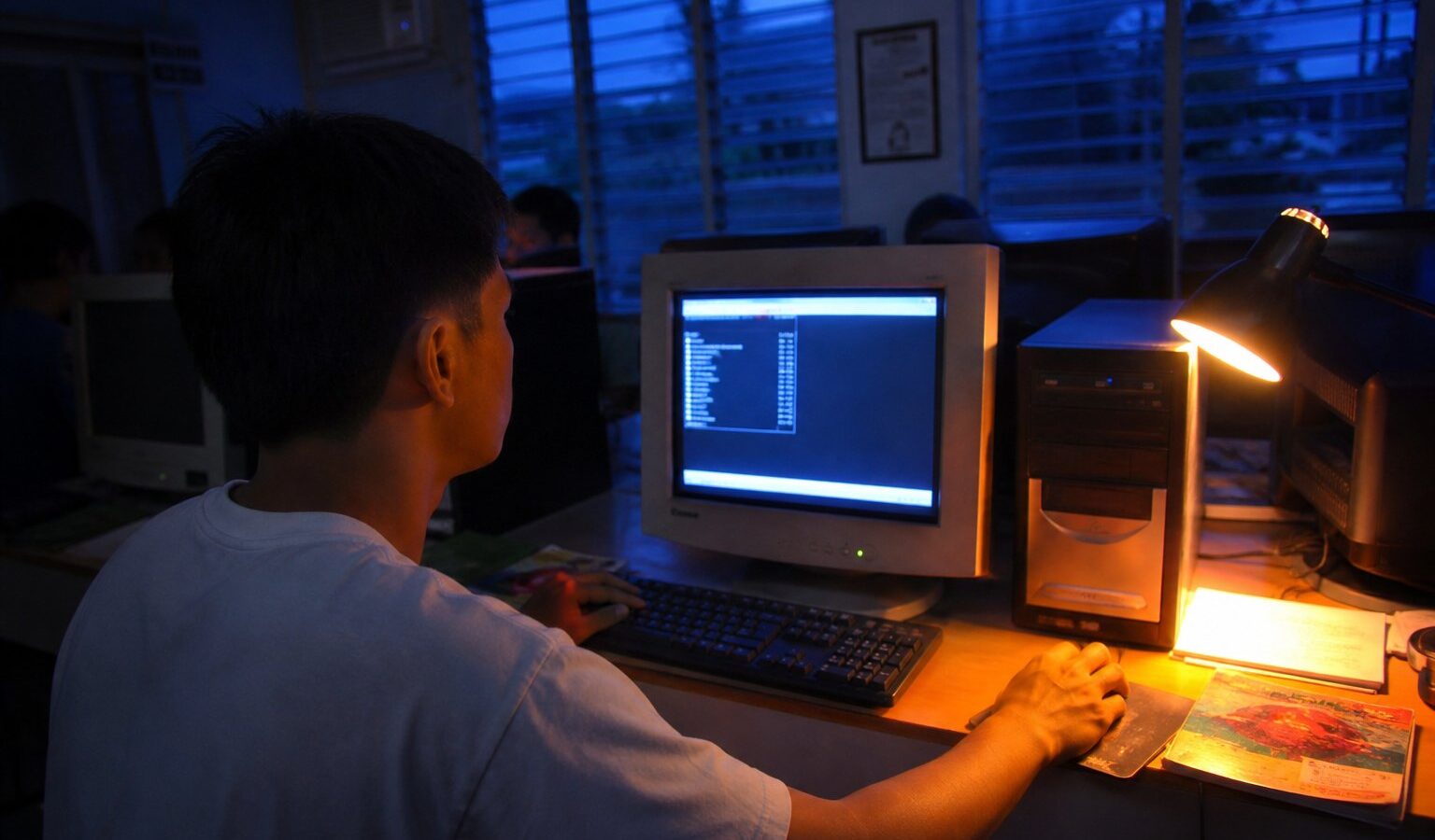 Desktop computer running a Linux terminal in a Filipino computer lab at dusk