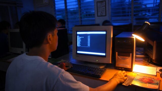 Desktop computer running a Linux terminal in a Filipino computer lab at dusk