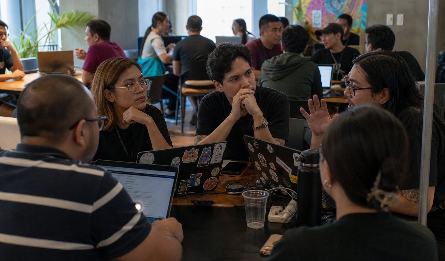 Tech community meetup around laptops in a Manila co-working space