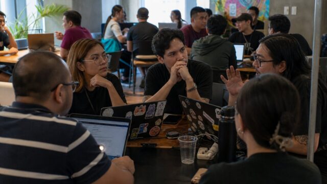 Tech community meetup around laptops in a Manila co-working space